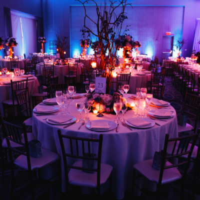 Decorated wedding hall with candles, round tables and centerpieces